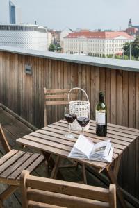 uma mesa de madeira com dois copos de vinho e um livro em Kokon Apartments em Leipzig