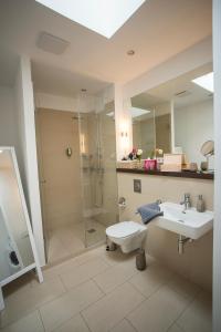 a bathroom with a shower and a sink and a mirror at Kokon Apartments in Leipzig