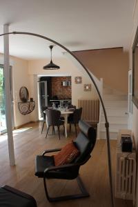uma sala de estar com uma cadeira e uma mesa em Charmante Maison de Ville avec Jardin quartier Prébendes em Tours