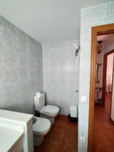 a bathroom with a white toilet and a sink at En la gloria. in Peniscola +17 photos