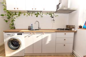 a kitchen with a washing machine and a sink at Apartamentul cu plante Etaj 4 in Mangalia