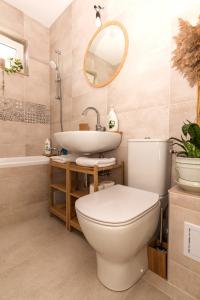 a bathroom with a toilet and a sink and a tub at Apartamentul cu plante Etaj 4 in Mangalia