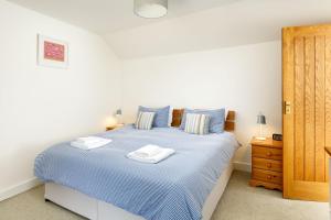 a bedroom with a bed with two towels on it at Little Pengelly Farm in Crowan