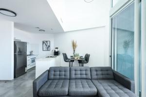 - un salon avec un canapé et une table dans l'établissement Spacious 3BR Duplex w Balcony in City Center by Sea N' Rent, à Tel Aviv