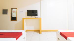 a room with two beds and a flat screen tv at RedDoorz @ Golden Skye Hotel Guagua in Guagua