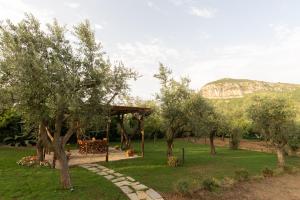 a garden with a gazebo and trees and mountains at La Gesina B&B in Piano di Sorrento