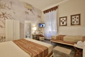 a hotel room with two beds and a desk at MADAMA GUEST HOUSE in Florence