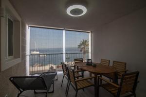 een eetkamer met een tafel en stoelen en een groot raam bij Apartment CasArosa in Bol