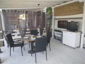 a dining room with a table and chairs and a tv at Camping Goldfish in Sozopol