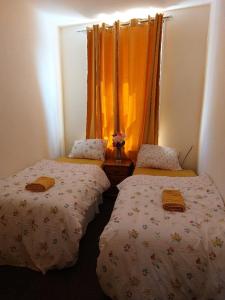 a room with two beds and an orange curtain at The Cosy 2 bedroom flat, sleeps 6 in Hebburn-on-Tyne