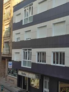 a tall building with windows on a city street at Apartamento TerradeAugas3 in Caldas de Reis +4 photos