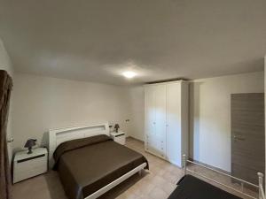 1 dormitorio con 1 cama y armario blanco en Domo sa prama 2, en Cala Liberotto