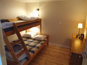 two bunk beds in a room with a lamp at Boathouse in Mjällom