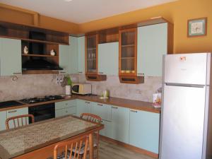 スペッキアにあるCasa vacanza terra-mareのキッチン(白いキャビネット、白い冷蔵庫付)