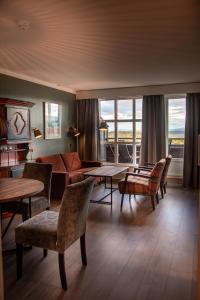 a living room with a couch and a table and chairs at Bergo Leiligheter in Beitostøl