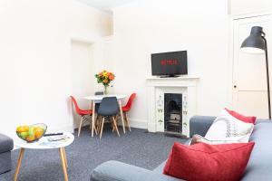 uma sala de estar com um sofá e uma mesa em K Suites - Montpellier Apartments em Cheltenham
