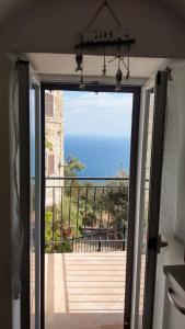una porta aperta su un balcone con vista sull'oceano di Tramonti e mare 1 a Cipressa