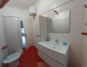 a bathroom with a sink and a toilet and a mirror at Maralis Portorosa in Furnari