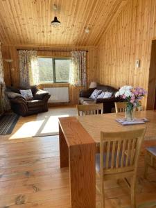 uma sala de estar com uma mesa e um sofá em Rural Wood Cabin - less than 3 miles from St Ives em Penzance