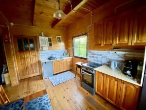 a kitchen with wooden cabinets and a stove at Brzozowy Chillout in Dubeninki