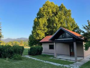 a small house with a red roof in a yard at Mountain Heart House in Bosanski Petrovac