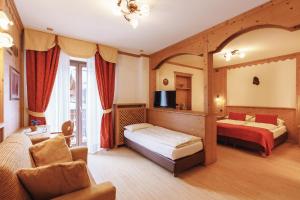 a hotel room with two beds and a tv at Albergo Centrale in San Martino di Castrozza