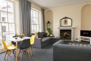 uma sala de estar com um sofá e uma mesa em K Suites - Montpellier Apartments em Cheltenham