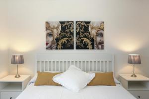 sypialnia z 3 obrazami na ścianie nad łóżkiem w obiekcie Naxos Sicilian Luxury Apartment w mieście Giardini Naxos