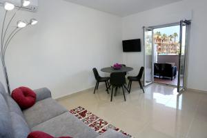 a living room with a couch and a table with chairs at Naxos Sicilian Luxury Apartment in Giardini Naxos