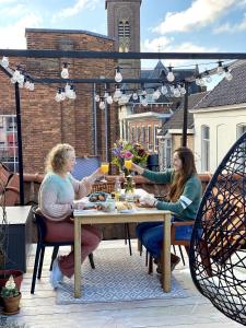 duas mulheres sentadas numa mesa num pátio em B&B Gasthuisstraat Dokkum em Dokkum
