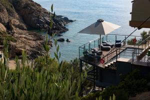 a beach with chairs and an umbrella next to the water at Studio Kalogridis in Kouniádhoi