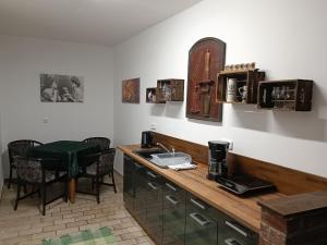 uma cozinha com um balcão com um lavatório e uma mesa em Ferienwohnung Alt Freyburg em Freyburg