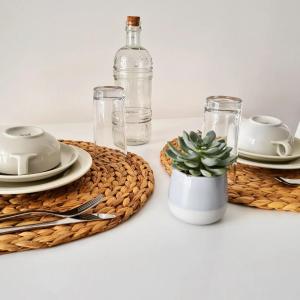 a table with plates and glasses and a cactus at 180Passi B&B in Lido Marini +32 photos