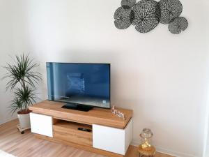 a flat screen tv sitting on top of a wooden tv stand at M-OASE Feeling Design I Küche I Netflix I Balkon in Braunschweig