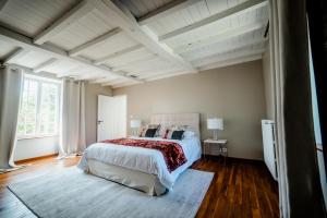 a bedroom with a large bed and a white ceiling at Gites Saint Martin - Le Couvent et sa piscine in Grosville