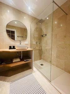 y baño con lavabo y ducha con espejo. en Lovely studio, en Marbella