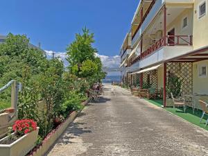 an empty street with flowers and a building at Akrotiri Rooms in Agiokampos