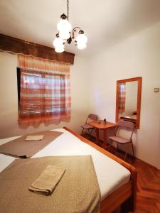 sypialnia z łóżkiem, stołem i lustrem w obiekcie Rooms Silvana w mieście Umag
