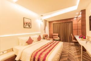 a hotel room with a bed and a desk at Hotel Park Elanza Coimbatore in Coimbatore +34 photos