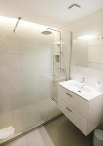 ein weißes Bad mit einer Dusche und einem Waschbecken in der Unterkunft Balcón del Mar Estepona in Estepona