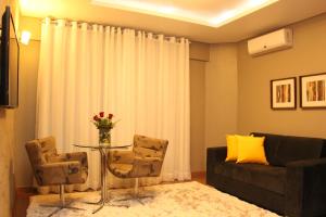 a living room with a couch and a table and chairs at Hotel Areias Brancas in Rosário do Sul