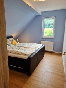 a bedroom with a bed in a room with a window at Buergerhaus Zeltingen Fewo in Zeltingen-Rachtig