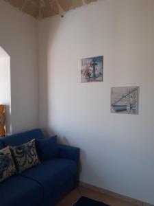 un sofá azul en una habitación con dos cuadros en la pared en Casa du Piscature, en Favignana 37 fotos más
