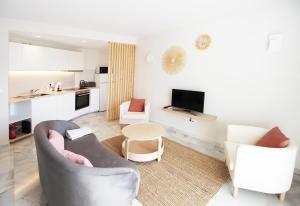 un soggiorno con divano e 2 sedie di Balcón del Mar Estepona a Estepona