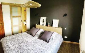 um quarto com uma cama e uma parede preta em Maison dans la Drôme em Montélimar
