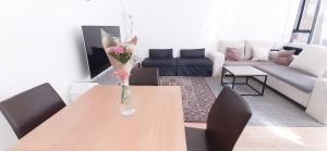 a living room with a table with a vase of flowers on it at Reykjavik Antique Rentals in Reykjavík