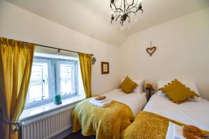 two beds in a room with a window at Old Horns Cottage, Higham Derbyshire in Alfreton