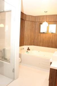 uma casa de banho com uma banheira, um WC e um lavatório. em Hotel Areias Brancas em Rosário do Sul