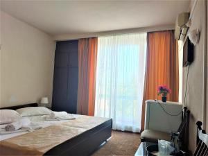 a bedroom with a bed and a large window at Hotel National in Mamaia