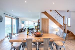 a dining room with a wooden table and chairs at Gualan Sands in Clachan